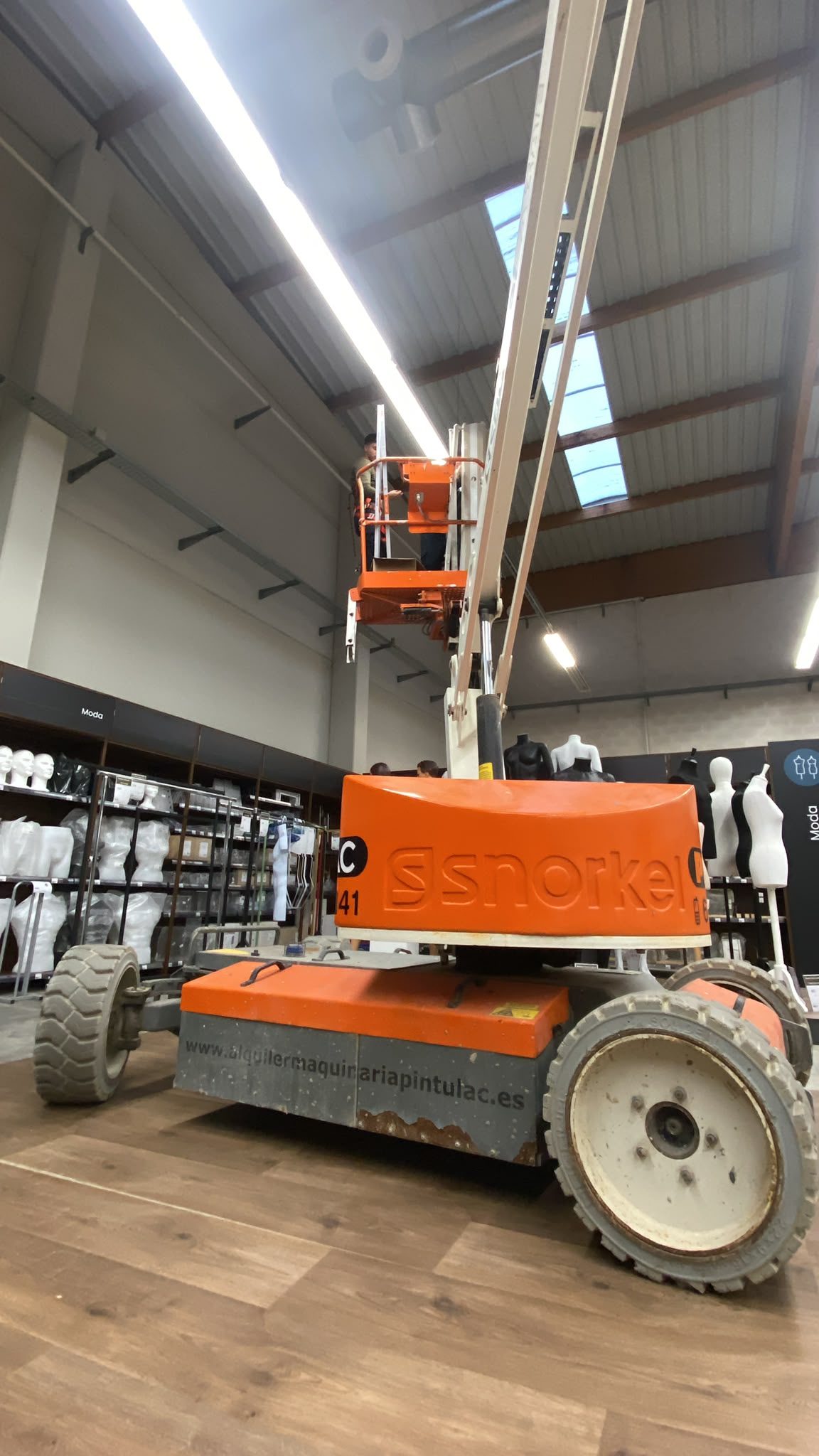 Técnico trabajando en altura en una instalación comercial
